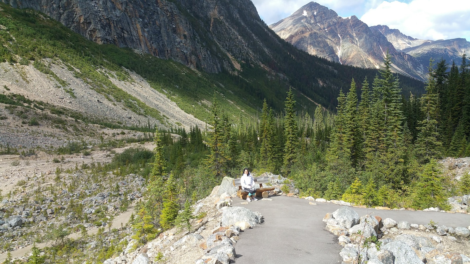 person in white shirt sitting on rock near river during daytime